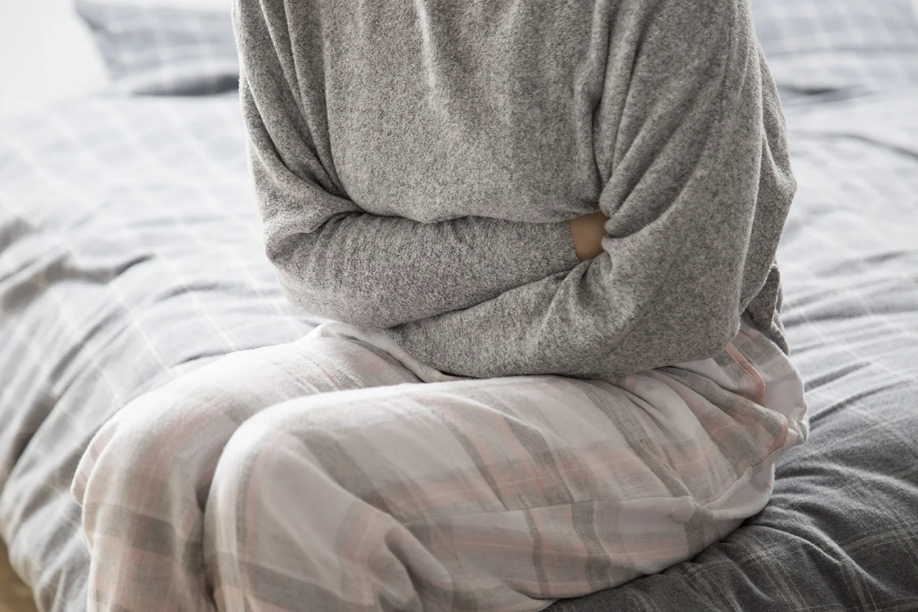 sick woman bed keeping hands stomach suffering from pain